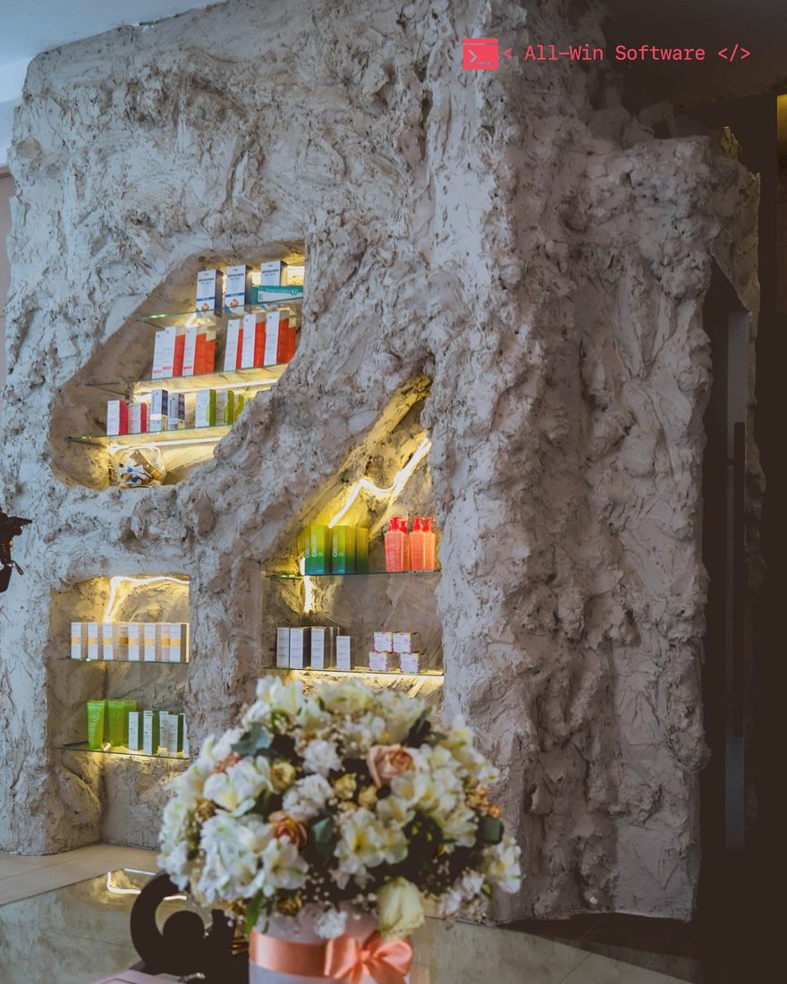 Estante de productos iluminado sobre pared de piedra en Clínica Cáceres
